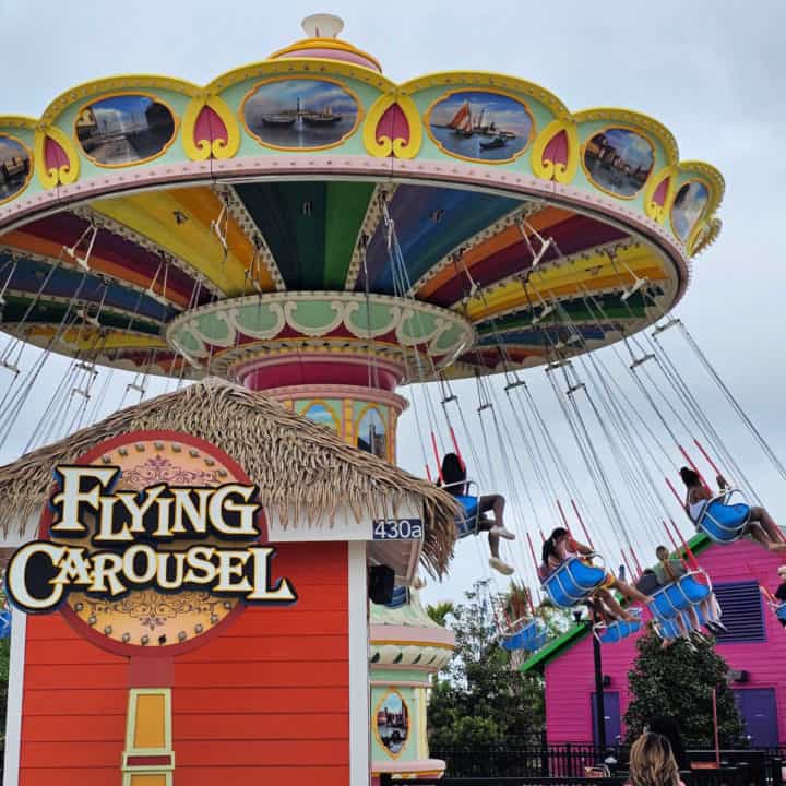 Flying Carousel sign with a large swing ride behind it