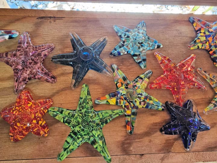multi colored glass starfish on a wooden shelf