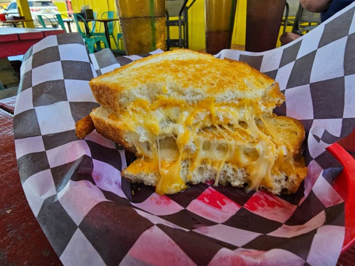 Grilled cheese with melty cheese on a checkered paper basket