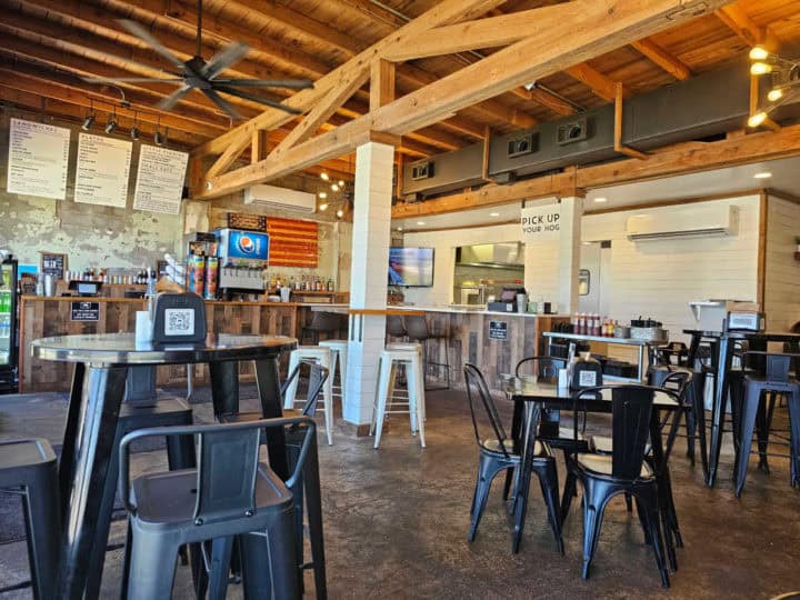 Indoor tables and chairs with menu boards, and a counter in the background