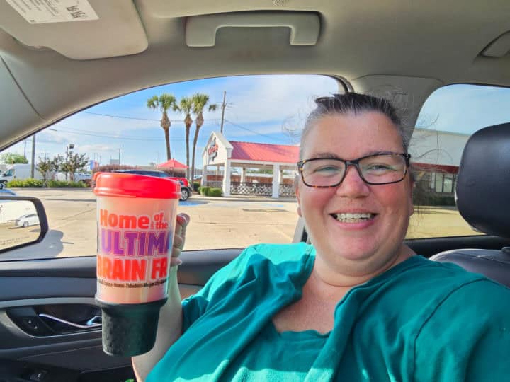 Tammilee holding large mug in the car
