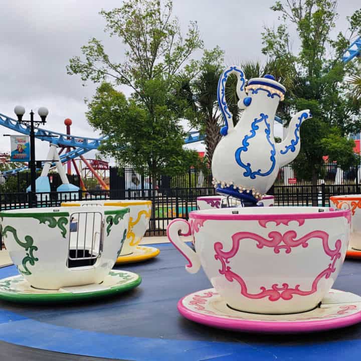 Colorful tea cup ride with a blue and white pitcher in the middle