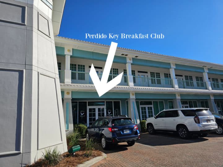 Perdido Key Breakfast club text with a white arrow pointing at the restaurant entrance