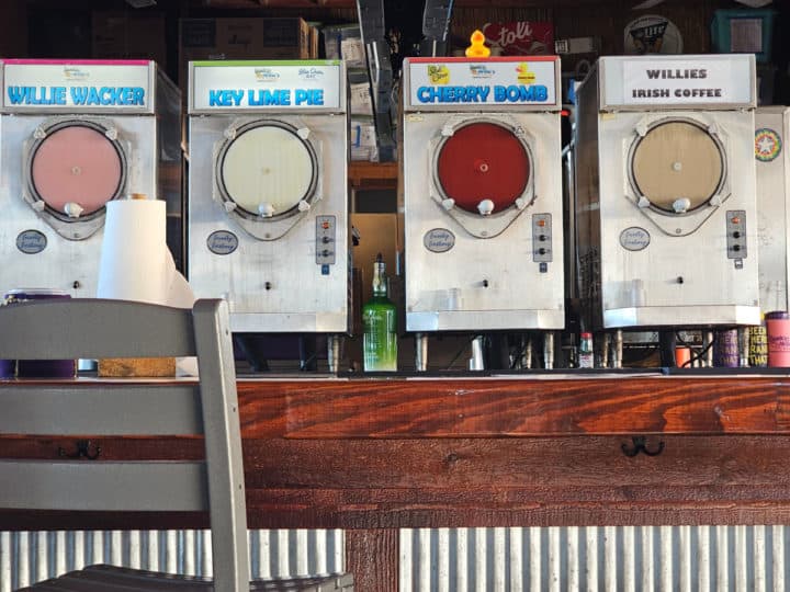 Frozen drink dispensers in a line with a rubber ducky on top of the Cherry Bomb