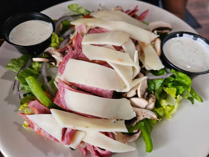 large salad with salami, bell peppers, and more