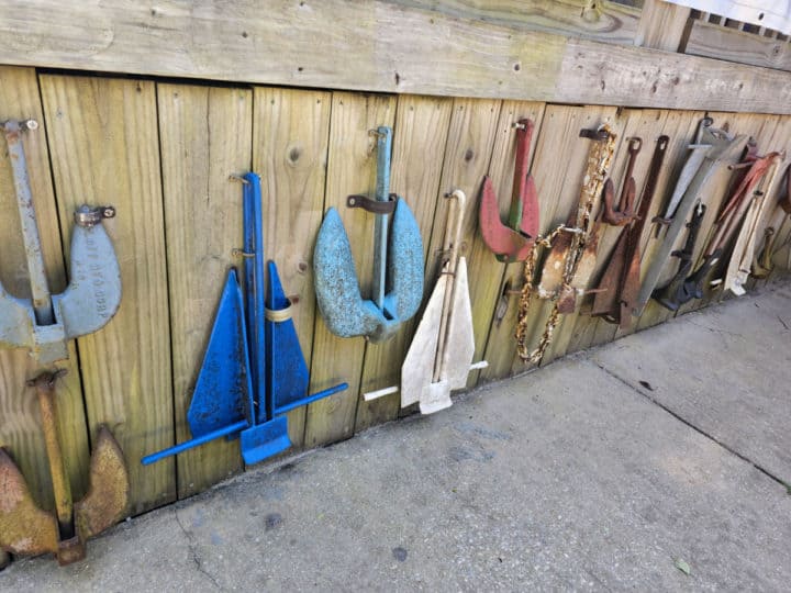 boat anchors hanging from a wooden fence wall