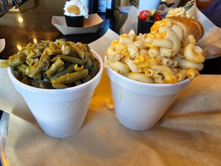 green beans and Mac and Cheese in containers in a paper lined basket