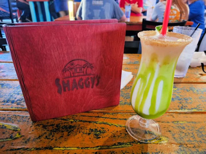 Shaggy's menu next to a key lime daiquiri in a hurricane glass