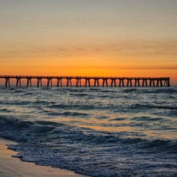 sunrise over the water and Navarre Beach Fishing Pier
