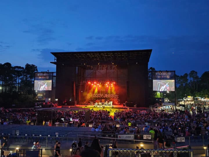 band on stage with lights seen from bleacher seats looking towards the stage