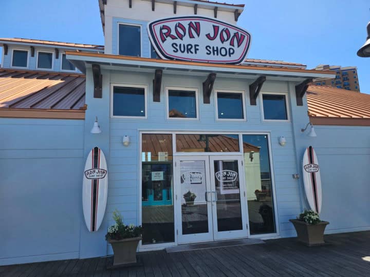 Ron Jon Surf Shop sign above a glass door with surfboards next to it