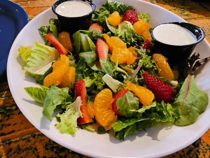salad with oranges, strawberries, and dressing in cups