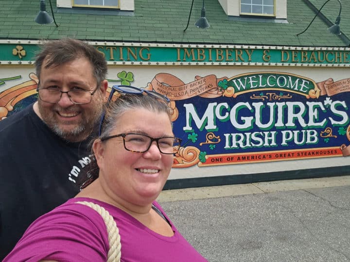 tammilee and john in front of the McGuire's Irish Pub mural on the side of the restaurant