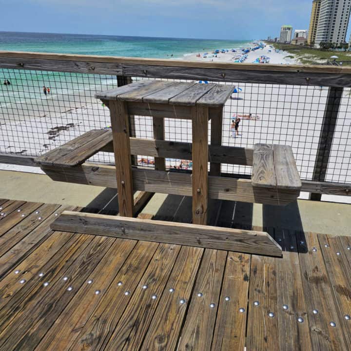 small picnic table with two benches on a pier