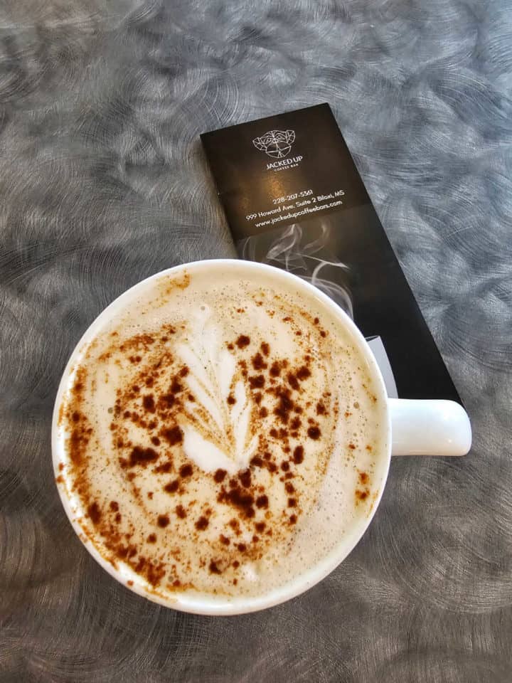 Chai tea in a white mug next to a menu