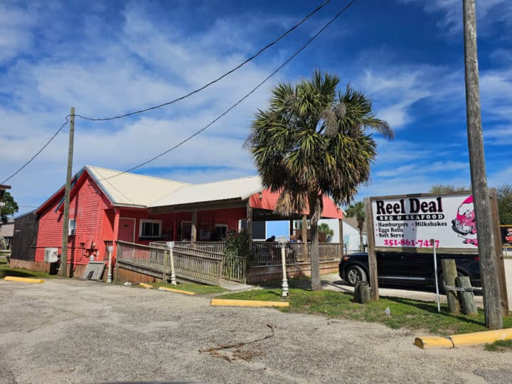 red building exterior with Reel Deal BBQ sign