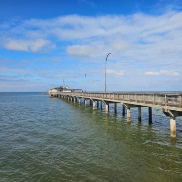 Fairhope Pier stretching into Mobile Bay on a sunny blue sky day