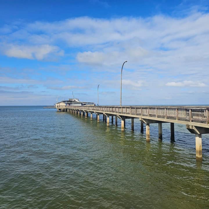 Fairhope Pier stretching into Mobile Bay on a sunny blue sky day