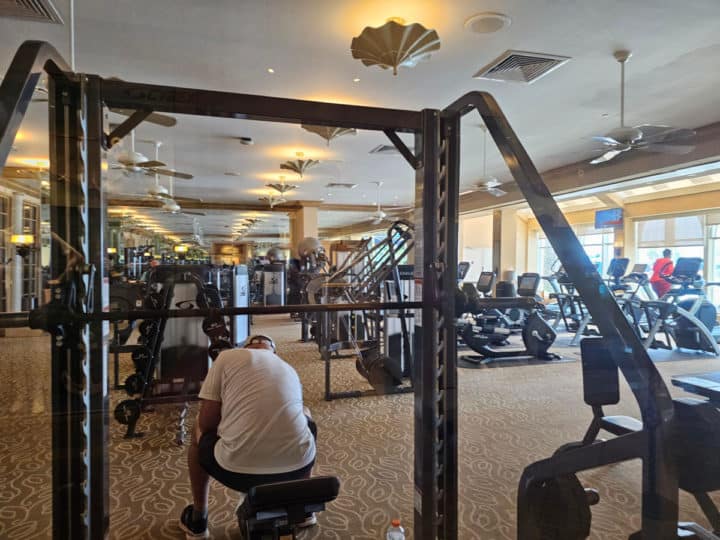 large hotel gym with person sitting on a weight bench