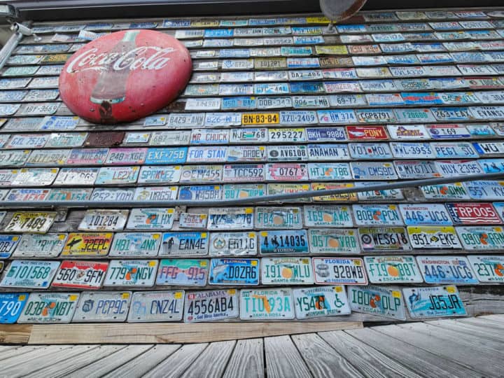 Wall of license plates and a Coca Cola red circle sign