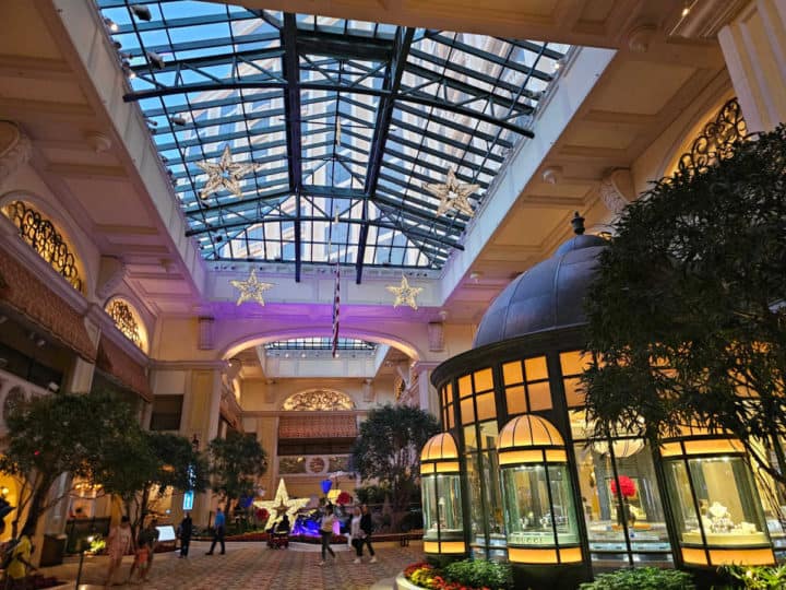 lobby area with atrium ceiling and store with light on. 