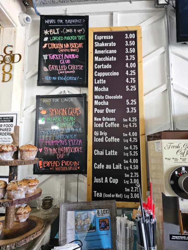 menu written on a chalkboard with coffee and tea options, food options on a 2nd chalkboard. 