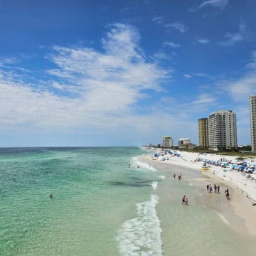 White sand beach with hotels on one side and turquoise water on the other.