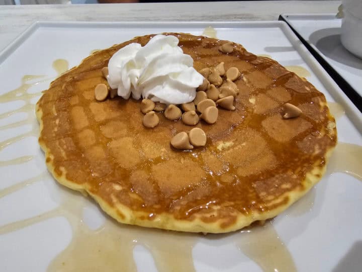 Pancake with peanut butter chips, whipped cream, and syrup