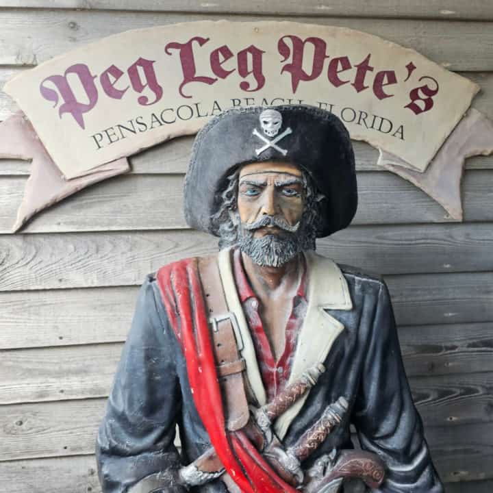 Pirate statue next to a Peg Leg Pete's Pensacola Beach Florida sign