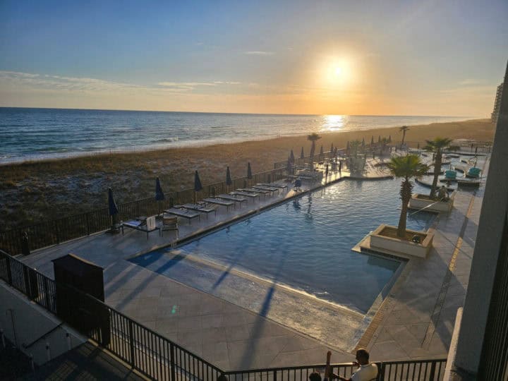 sunset in the distance over the water and the Springhill Suites Pool on Navarre Beach