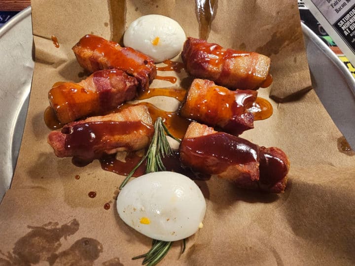 Pork belly bites and pickled eggs on a paper lined tray