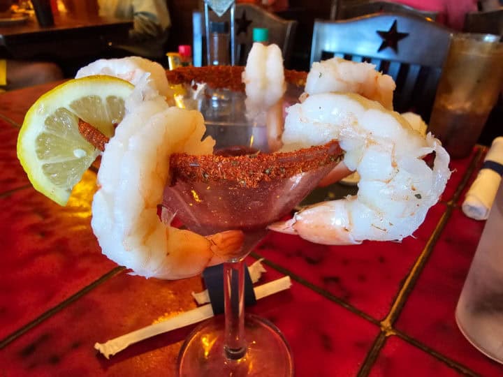 Shrimp cocktail in a martini glass with lemon wheel