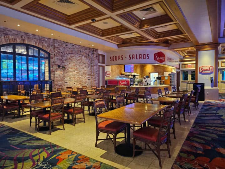 Snacks sign over a counter near tables and chairs