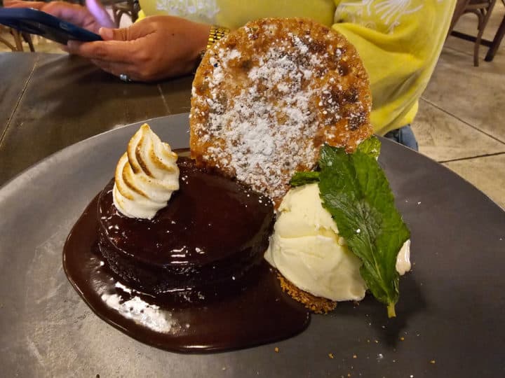 Sticky Toffee Pudding with ice cream and a cookie on a dark plate