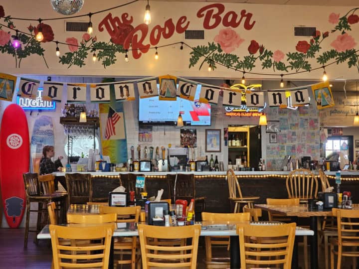 The Rose Bar painted above a bar with tall tables and chairs