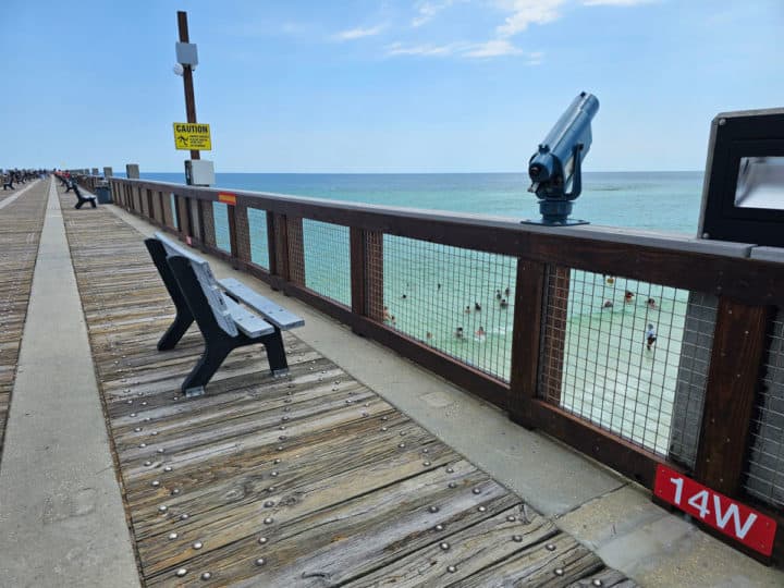 Bench and viewfinder on the side of a pier