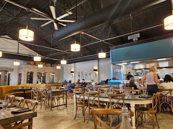 restaurant interior with tables and chairs, and open kitchen 