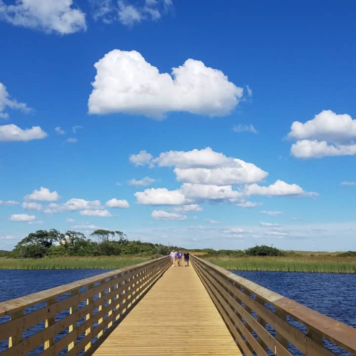 Walkway over water with clouds in the sky