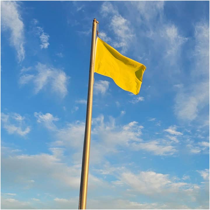 Yellow Flag on a pole with blue skies