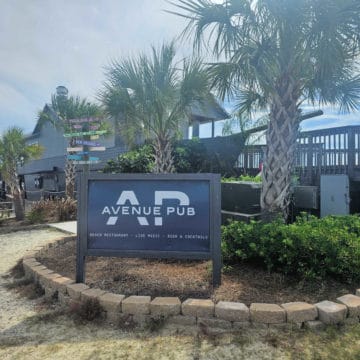 Avenue Pub Sign in front of a pirate ship shaped building with palm trees