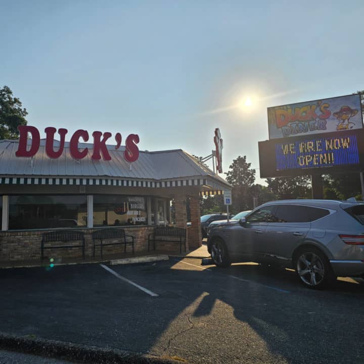 Duck's red sign over the building next to a Duck's Diner sign and parking lot