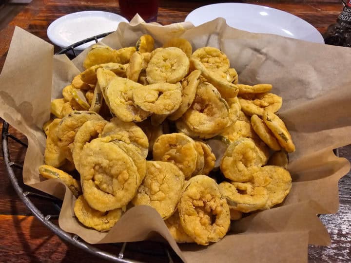 Fried pickles in a paper lined basket. 