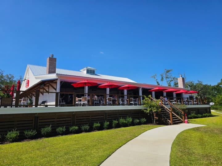 Outdoor restaurant seating on a deck with large red umbrellas