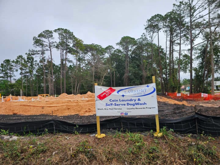 Construction area with a sign for the Laundry Lounge opening in 2025 Gulf Shores