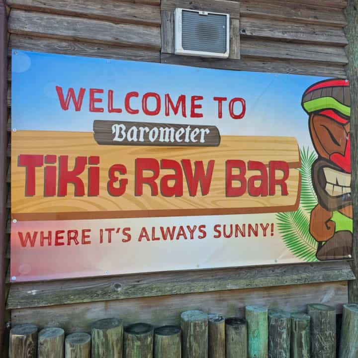 Welcome to Barometer Tiki & Raw Bar sign with a tiki figure next to it.