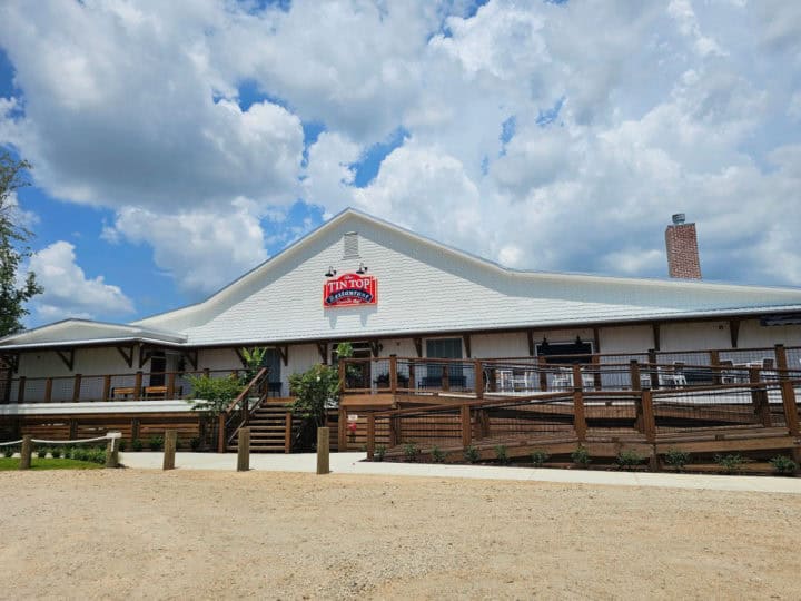 Tin Top Restaurant sign on a white building with large outdoor deck