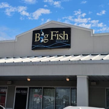 Big Fish restaurant sign on a white building above the entrance