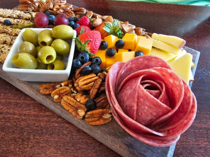 Charcuterie Board with salami roase and a bowl of olives