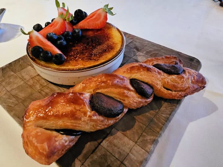 creme brule and pain au chocolate croissant on a wooden board