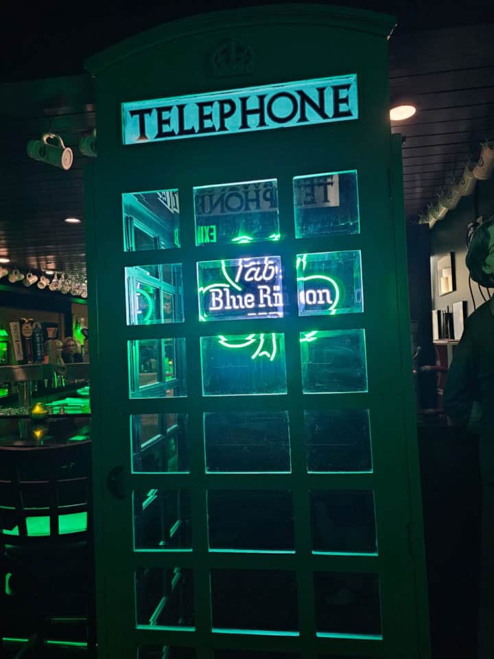 Green Irish phone booth with a Pabst Blue Ribbon neon light inside